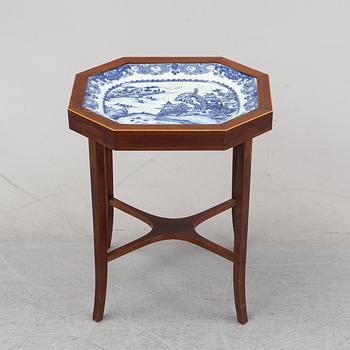 A mahogany veneered table with a Chinese blue and white porcelain charger, Qianlong (1736-95).