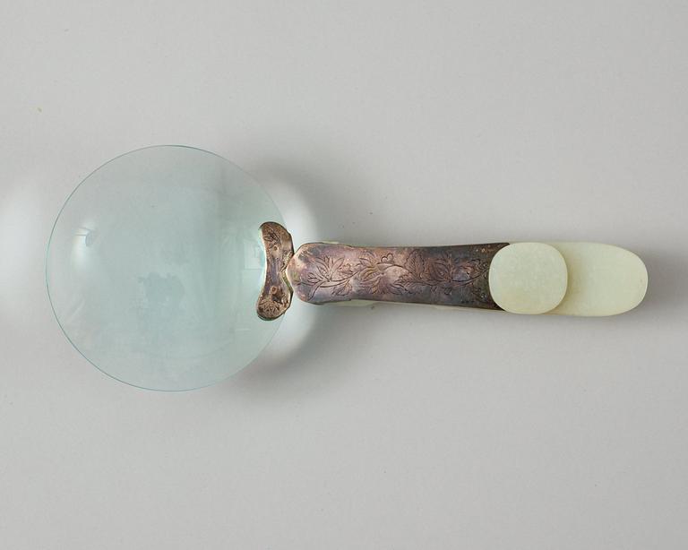 A Chinese archaistic nephrite belt hook, mounted as a magnifying glass.