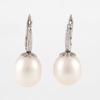 A pair of 18K gold earrings with cultured freshwater pearls and round brilliant-cut diamonds.