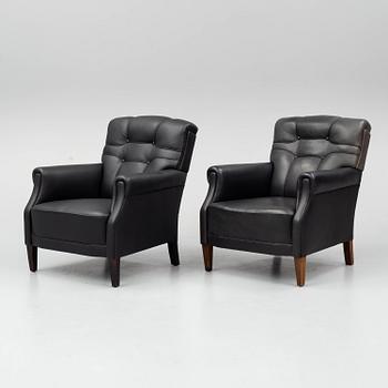 A pair of leather armchairs, early 20th century.