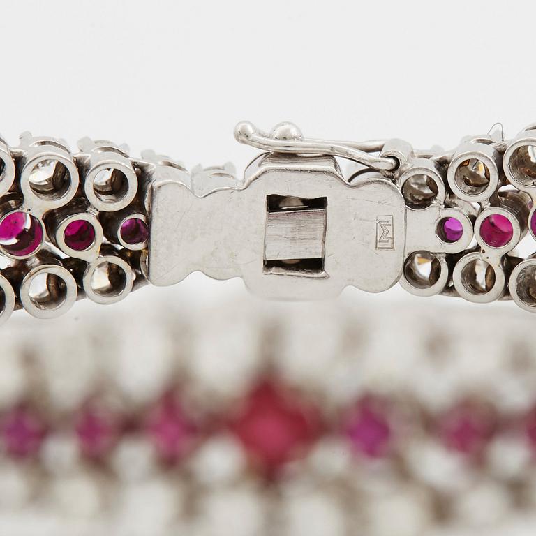 An 18K white gold bracelet set with rubies and round brilliant-cut diamonds.