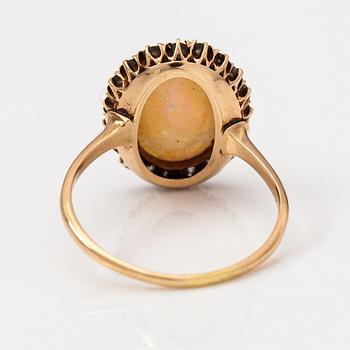 A 14-17K gold ring with a ca. 3.50 ct opal and old-cut diamonds ca. 0.57 ct in total according to certificate.