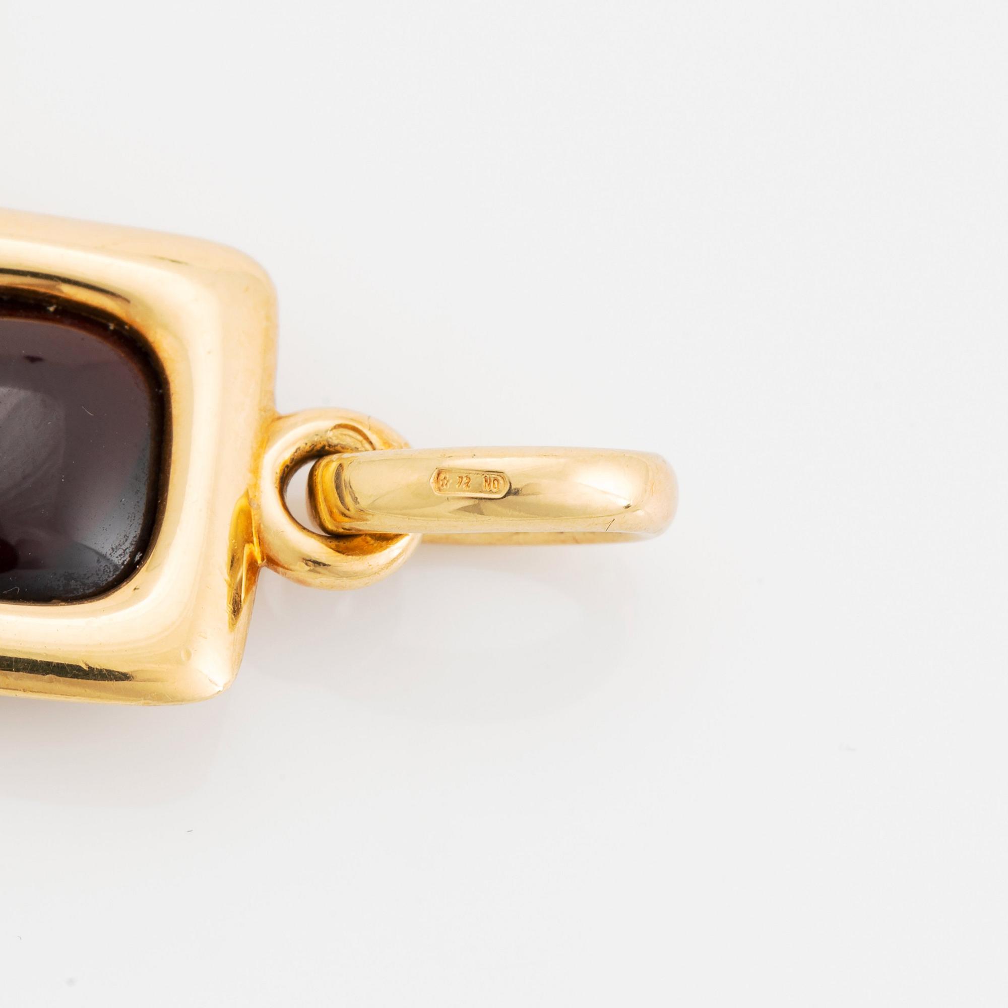 An 18K gold and garnet Pomellato cross.