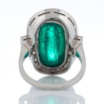 A platinum ring set with a cabochon-cut emerald ca 7 cts and brilliant and baguette-cut diamonds.