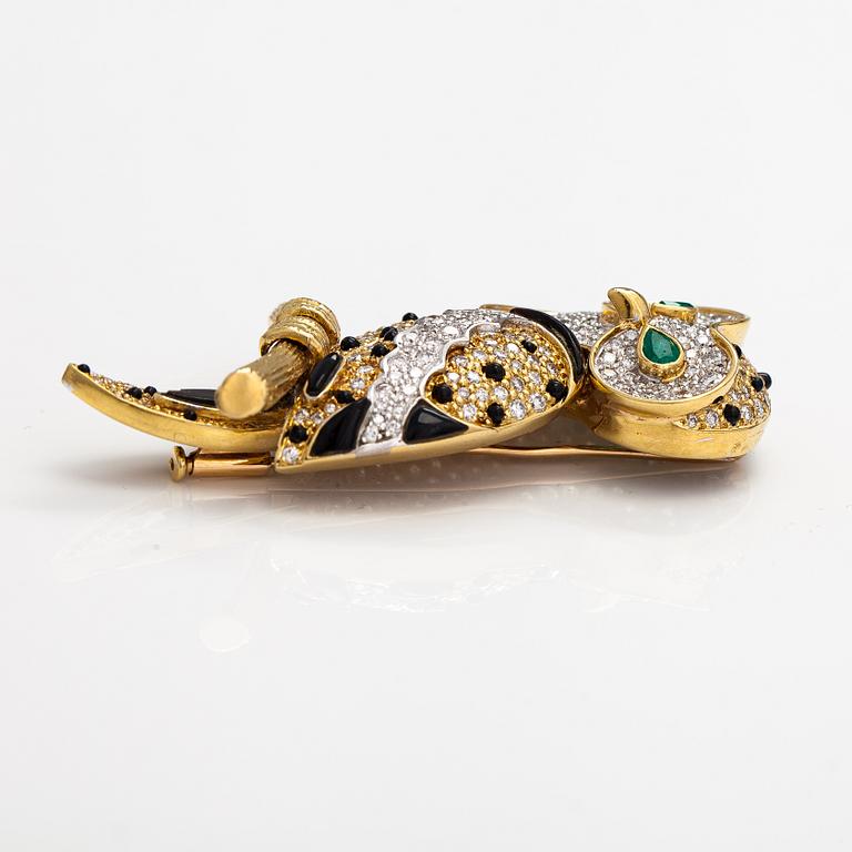 An owl brooch made of gold with diamodns ca. 4.00 ct in total, emeralds and onyx.