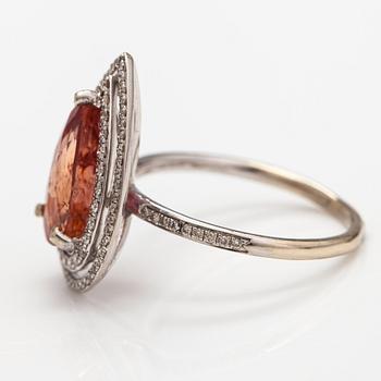 A 13-14K white gold ring with a topaz and diamonds ca. 0.35 ct in total.