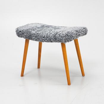 A mid 20th Century stool with new sheepskin upholstery.