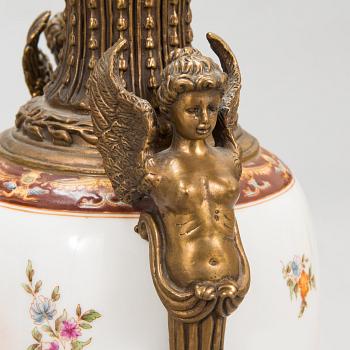 A pair of urns with lids, in bronze and porcelain, 20th century.