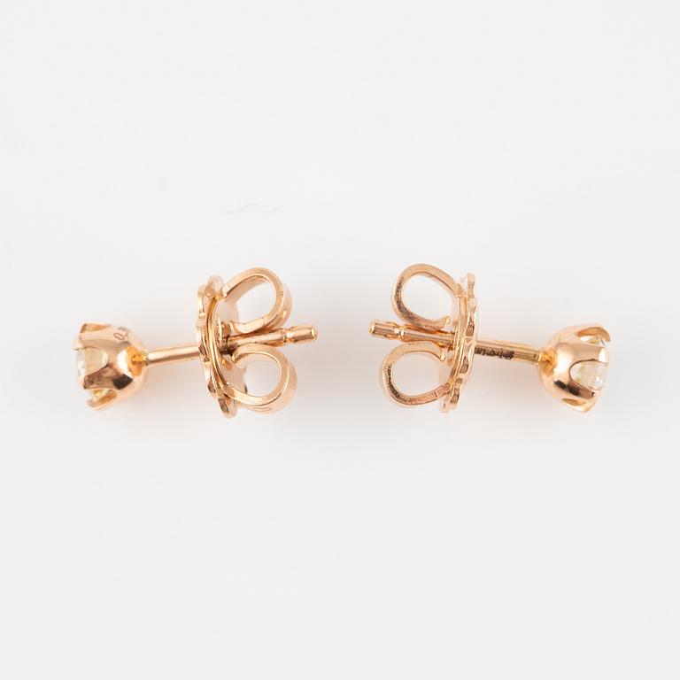 A pair of 14K gold earrings with round brilliant-cut diamonds.