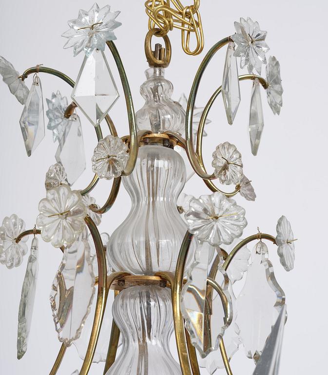 A near pair of rococo-style gilt brass and cut glass six-branch chandeliers, 19th century incorporating older elements.