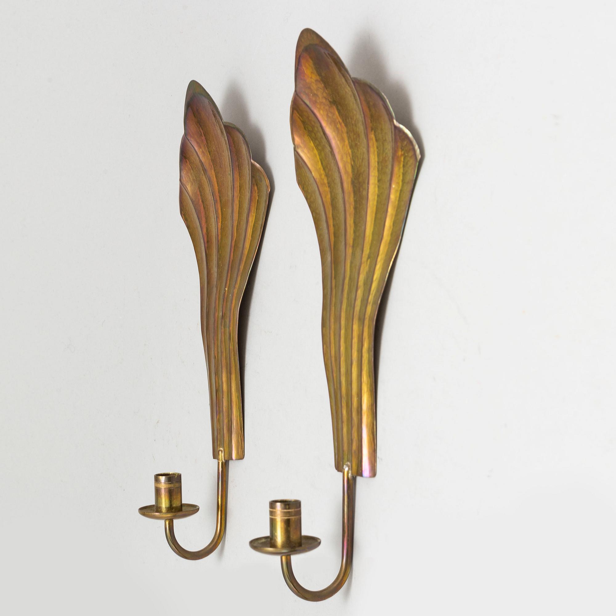 Four brass wall sconces  and one brass plate by Lars Homström, Arvika, second half of the 20th century.