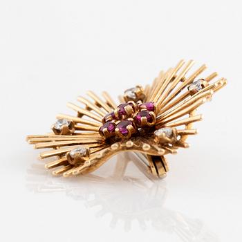 An 18K gold brooch set with round brilliant-cut diamonds and rubies.