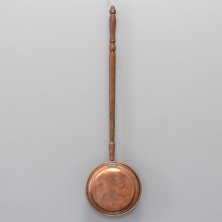 A 18th century copper bed warmer.