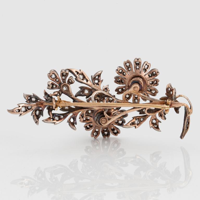 A 14K gold and silver brooch set with old- and rose-cut diamonds, en tremblant.