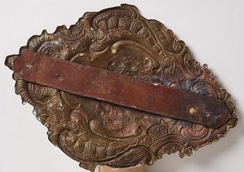 A pair of North European Rococo two-branch repoussé brass reflector plates, mid 18th century.