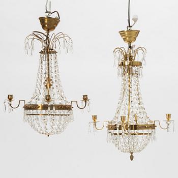 A contemporary matched pair of chandeliers for four candles each.