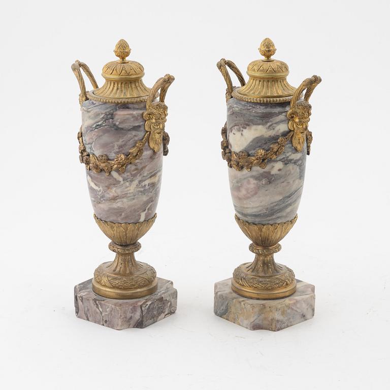 A pair of Louis XVI style urns with covers.