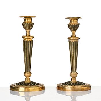 A pair of French Empire ormolu and patinated bronze candlesticks, early 19th century.