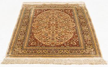 A silk Hereke rug, circa 104 x 70 cm.