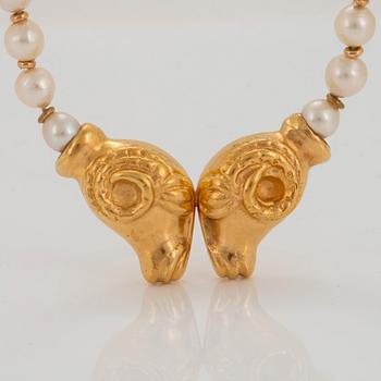 An 18K gold pendant with a cultured pearl necklace.