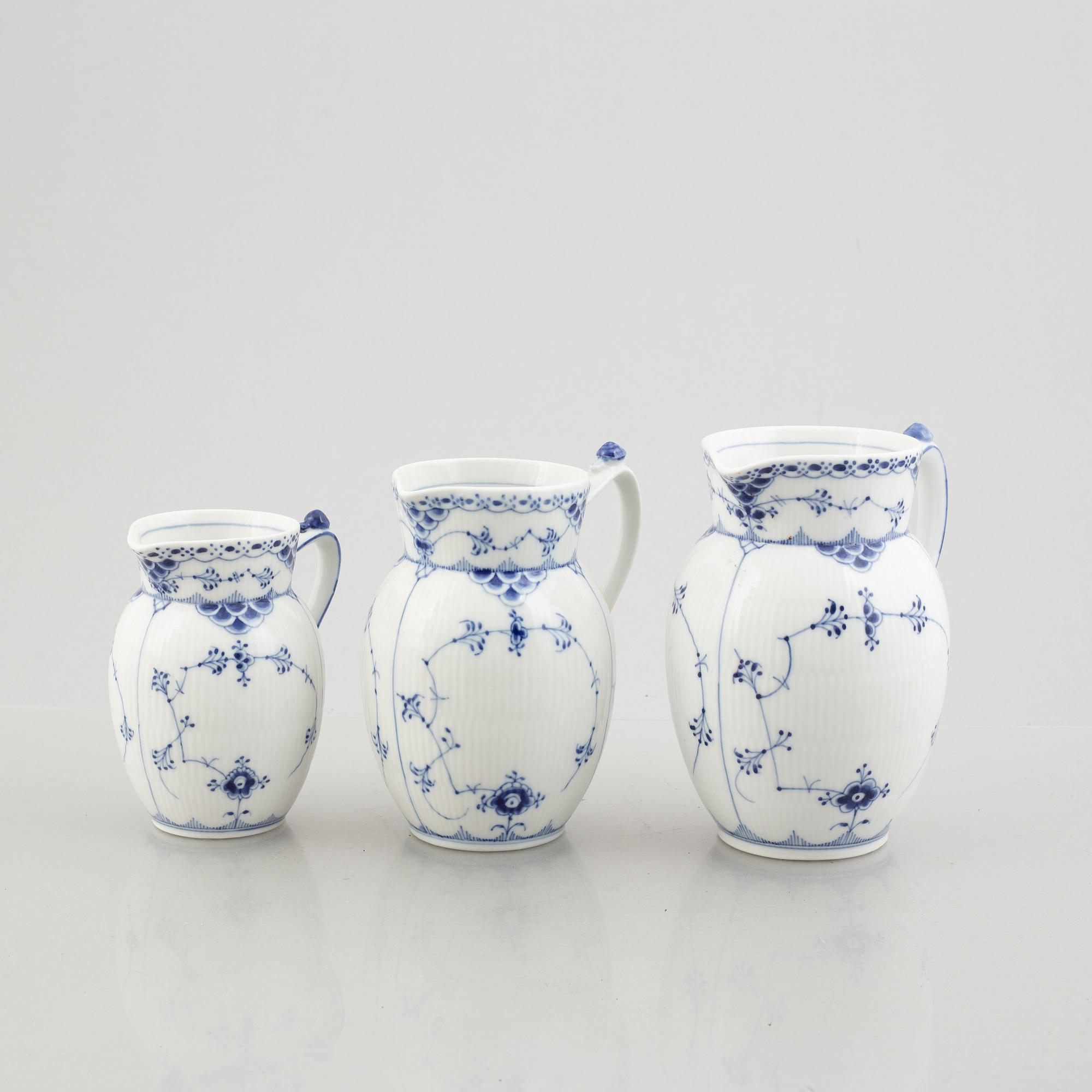 Three 'Blue Fluted Half Lace' / 'Musselmalet' porcelain jugs, Royal Copenhagen, model 562, 561, 763, 1898-1923 and 1962.