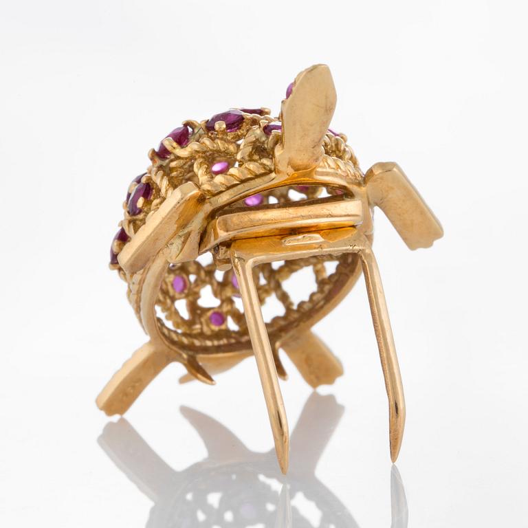 A Cartier turtle brooch in 18K gold set with rubies.