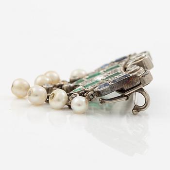 Brooch in platinum set with old-cut diamonds, sapphires, emeralds, and pearls.