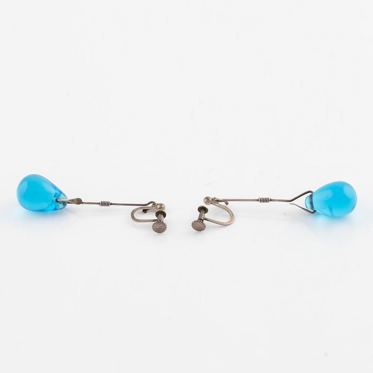 A pair of silver earrings with blue glass drops, likely by Torun Bülow-Hübe.