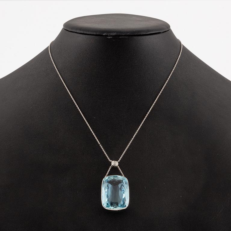 A platinum necklace with a faceted aquamarine and an oval old-cut diamond.