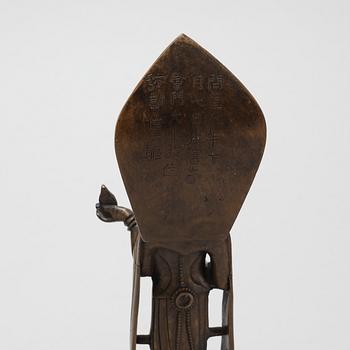 A Chinese temple bell and a figure of a deity, 20th Century.