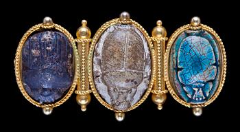 884. Brooch set with three carved and glazed steatite or ceramic scarab amulets, 1860's.