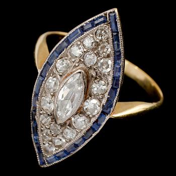RING, 18k guld med marquiseslipad diamant ca 0.30 ct, 18 små diamanter tot ca 0.40 ct samt blå safirer. Vikt 4 g.