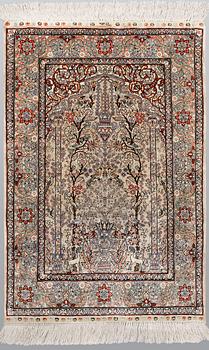 An oriental silk rug, approx. 95 x 63 cm.