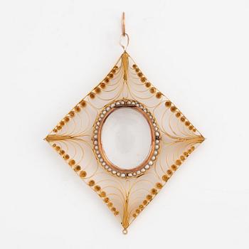 Pendant in gold filigree with frame, seed pearls, and glass.
