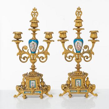 A French Louis XVI-style mantel clock and a pair of candelabra, late 19th Century.