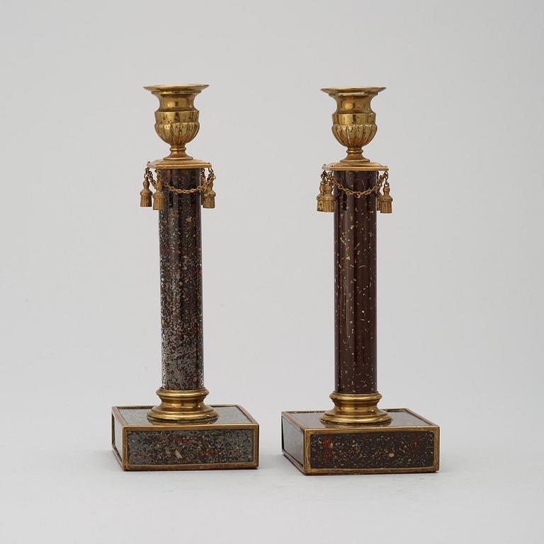 A pair of late Gustavian style 19th century porphyry imitation glass and brass candlesticks.