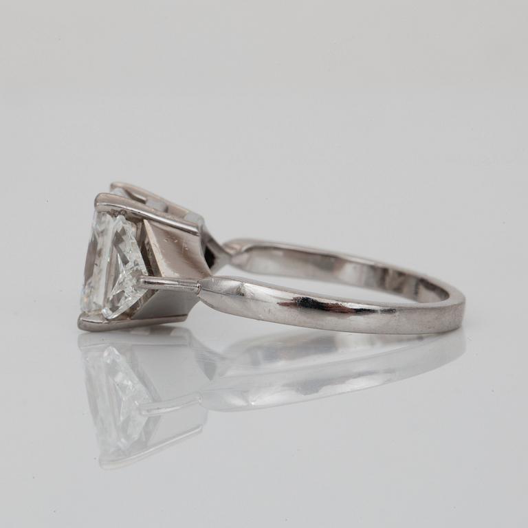 A radiant-cut diamond, 3.01 cts ring. Flanked by two triangular cut-diamonds, 0.50 ct each. E/VS2, certificate from HRD.
