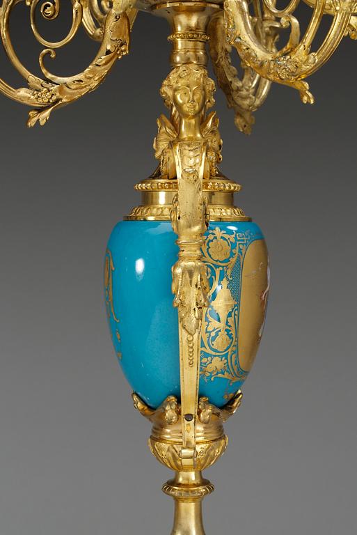 A pair of seven-light gilt bronze chandelabras with porcelain settings, 19th Century, presumably Russian.