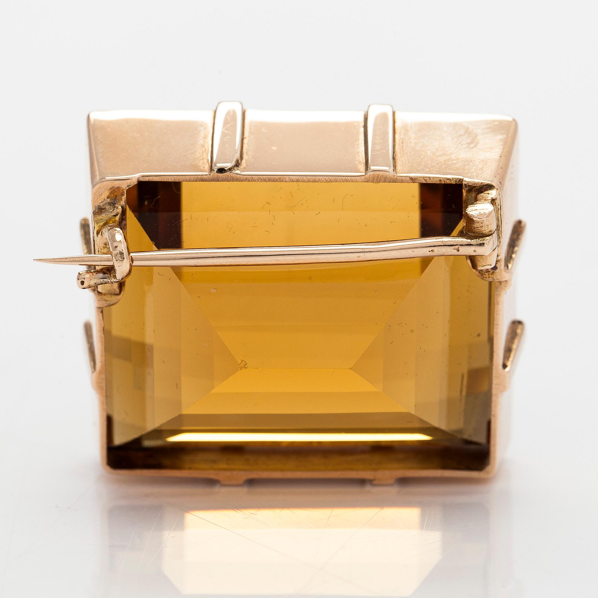 A ca 13K gold brooch, set with a step-cut Madeira citrine approximately 119.0 ct.