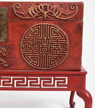 A red lacquered chest on a later stand, late Qing dynasty, 19th Century.