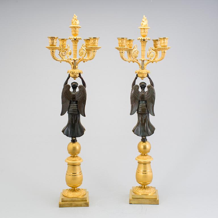 A large pair of first half of the 19th century gilt and patinated bronze five-light candelabra.