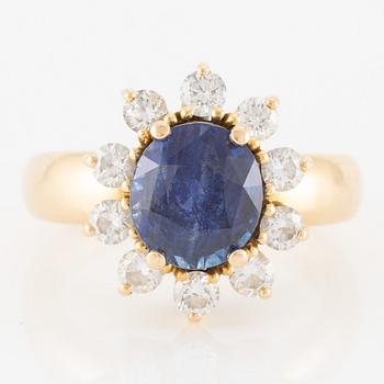 Ring in 18K gold with a faceted sapphire and round brilliant-cut diamonds.
