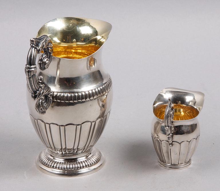 MJÖLK- RESP GRÄDDKANNA, 2 st, empire, Mattias Helén, Västervik resp Gustaf Folcker, Stockholm. 1845 resp 1844.