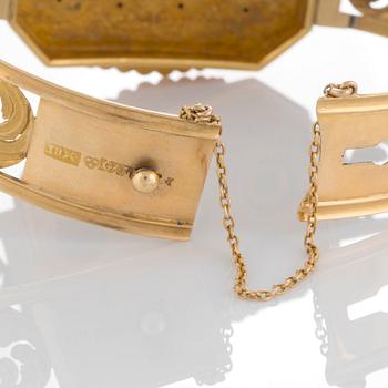 An 18K gold bracelet set with three pearls.