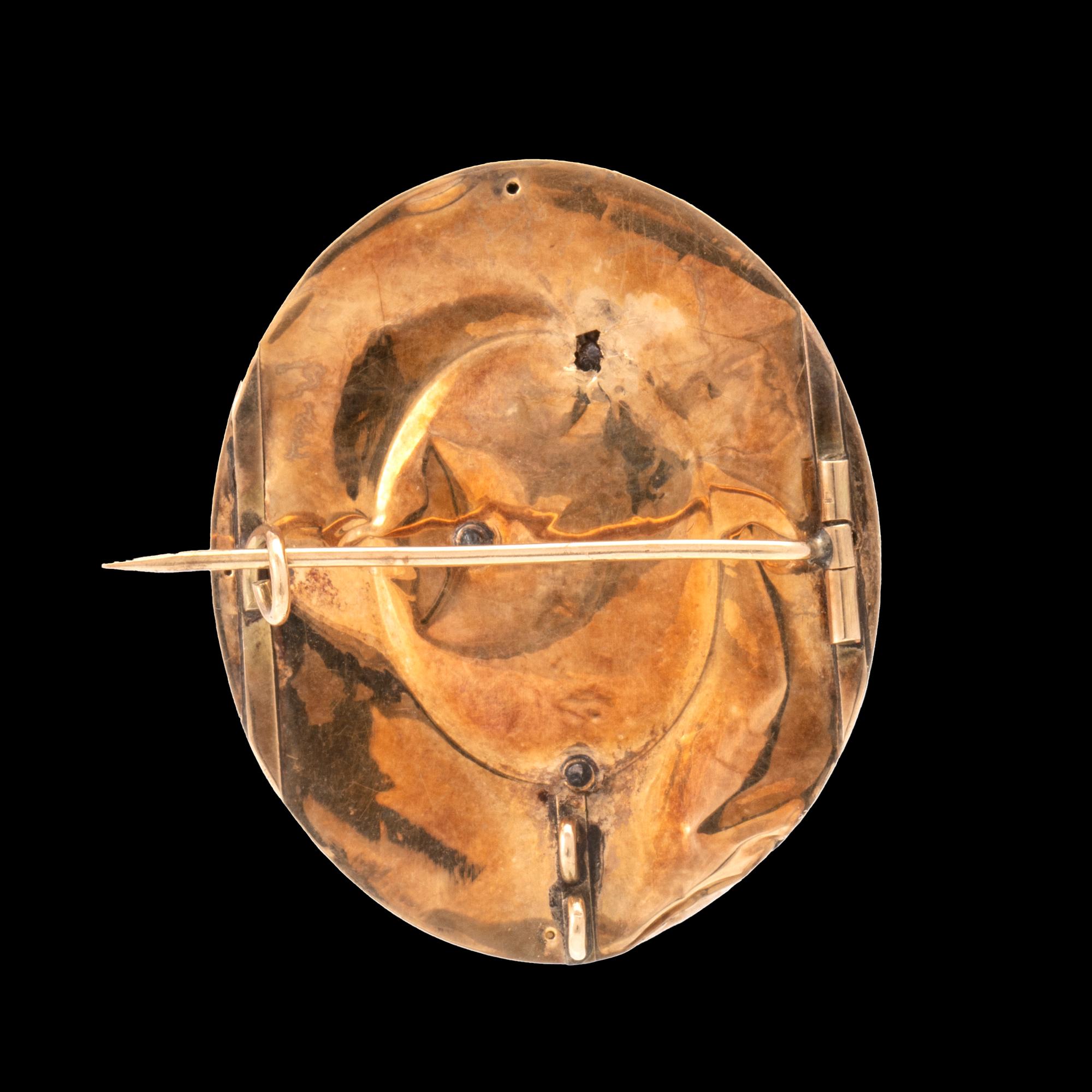 A 14K gold brooch.