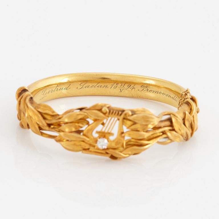 An 18K gold bangle set with an old-cut diamond.