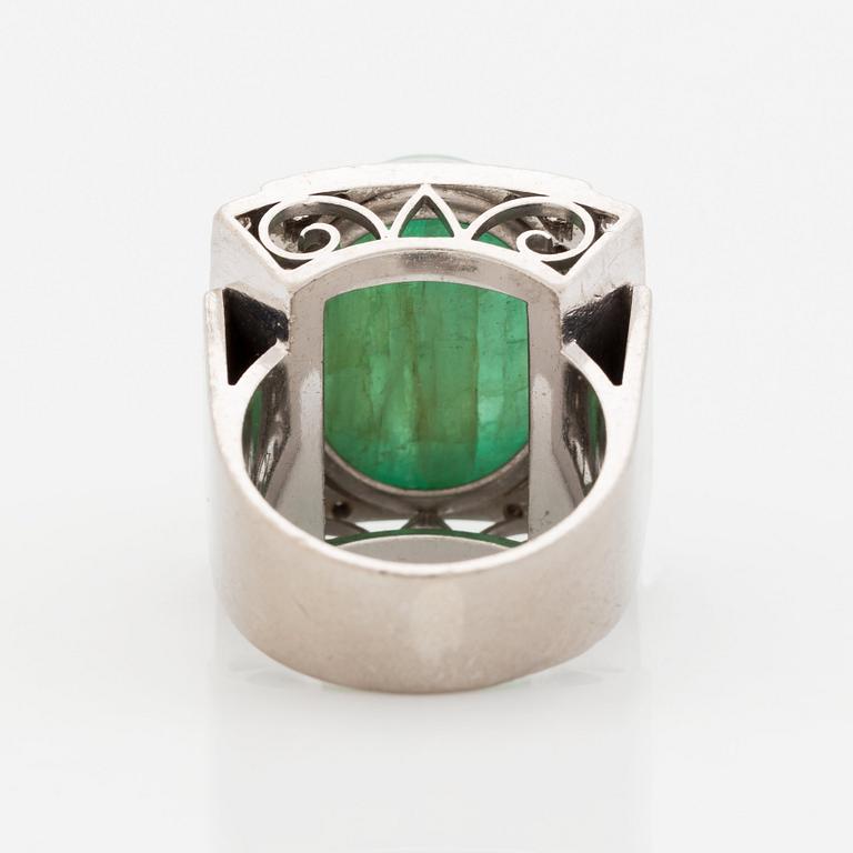 An 18K white gold ring set with a cabochon-cut emerald and round- and eight-cut diamonds.