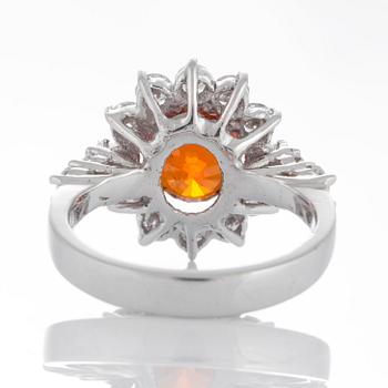 Ring med en fasettslipad spessartingranat samt runda briljantslipade diamanter.
