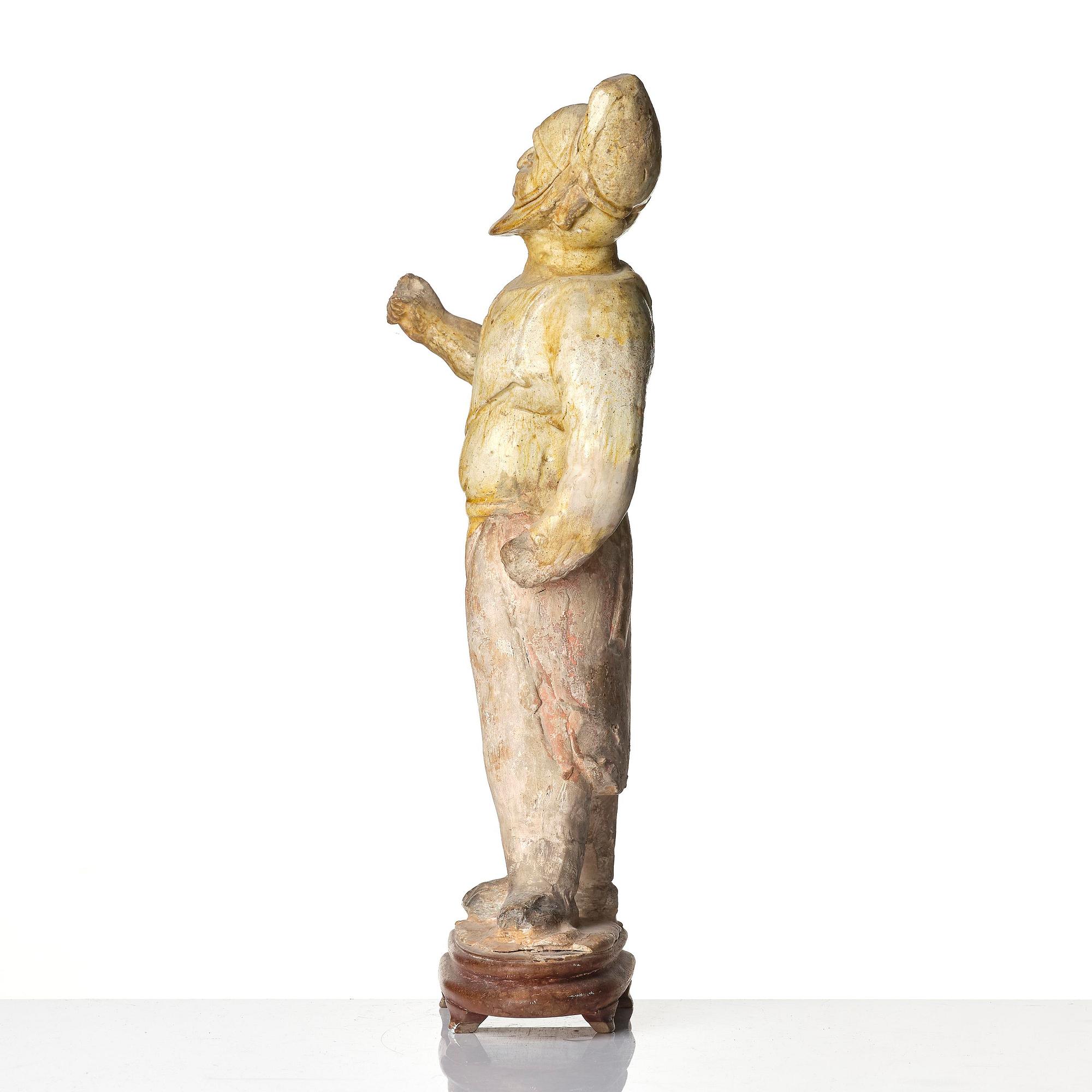 A yellow glazed potted figure of a groom, Tang dynasty (618-907).