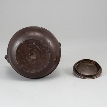 A Japanese iron tea pot with bronze cover, signed.